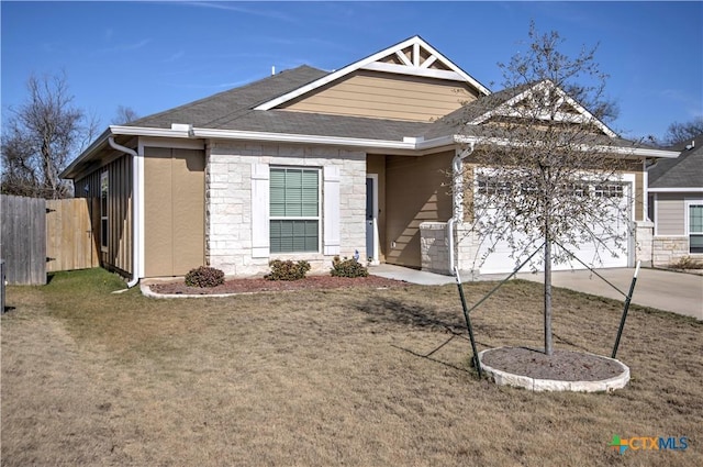 craftsman inspired home with a garage and a front lawn