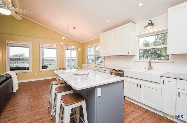 kitchen with white cabinets, vaulted ceiling, and a kitchen island