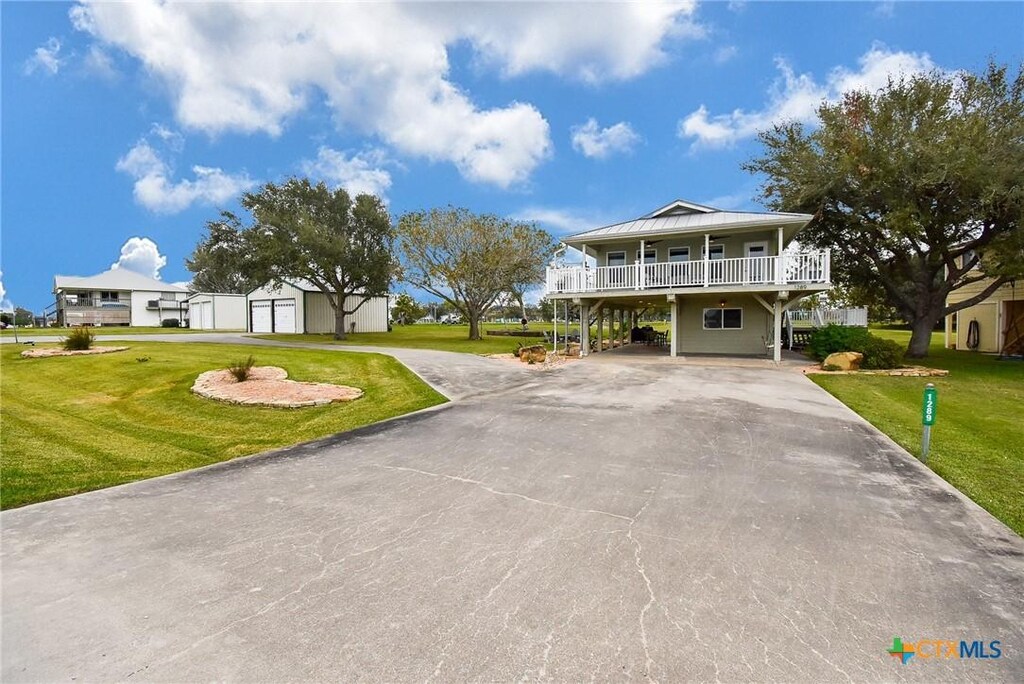 1289 W Bayshore Dr, Palacios, TX 77465 - view of front of property featuring a front lawn, a porch, and a carport