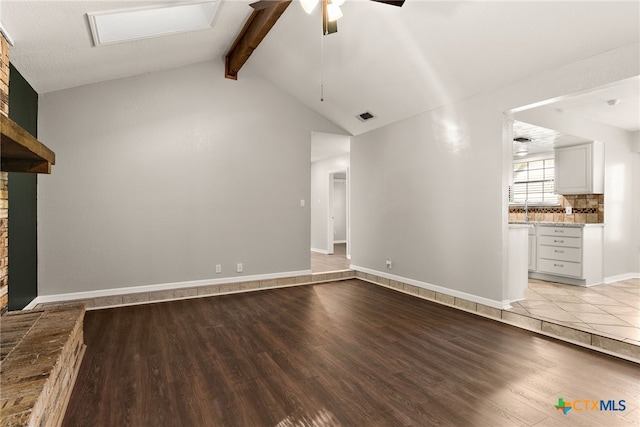 unfurnished living room with vaulted ceiling with beams, a ceiling fan, visible vents, baseboards, and light wood finished floors