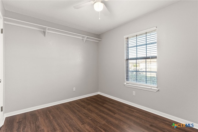 spare room with dark wood-style floors, ceiling fan, and baseboards