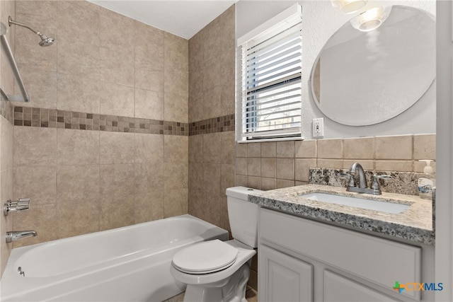 full bathroom with toilet, vanity, bathtub / shower combination, and tile walls