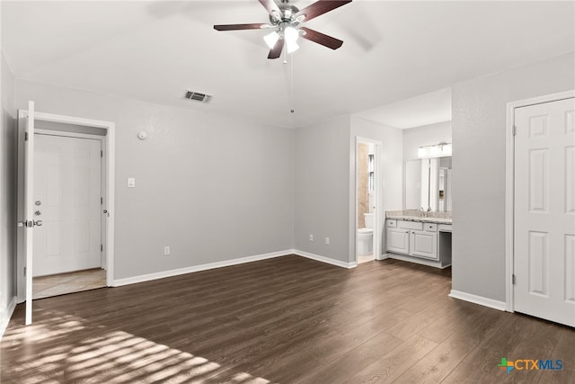 unfurnished bedroom with visible vents, dark wood-type flooring, a ceiling fan, ensuite bath, and baseboards