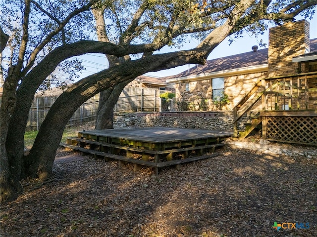 exterior space with fence, a chimney, and a wooden deck