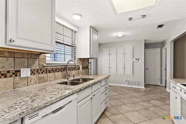 kitchen featuring visible vents, a sink, dishwasher, and white cabinetry