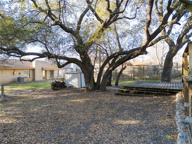 view of yard featuring a fenced backyard, a shed, cooling unit, and an outdoor structure