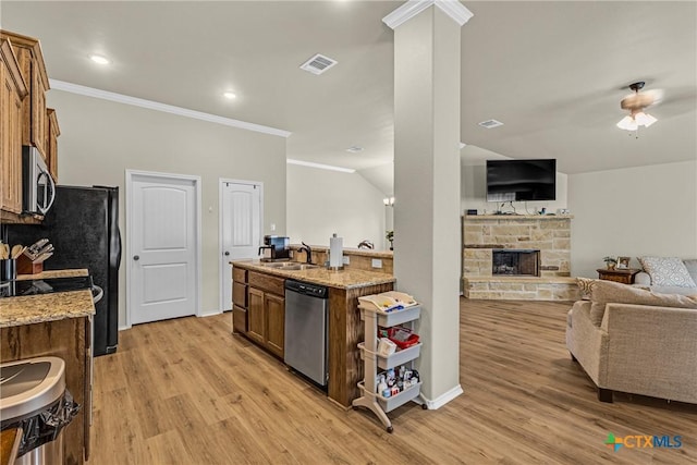 1703 Fossil Trl, Belton, TX 76513 - kitchen featuring stainless steel appliances, open floor plan, light wood-style flooring, crown molding, and a fireplace