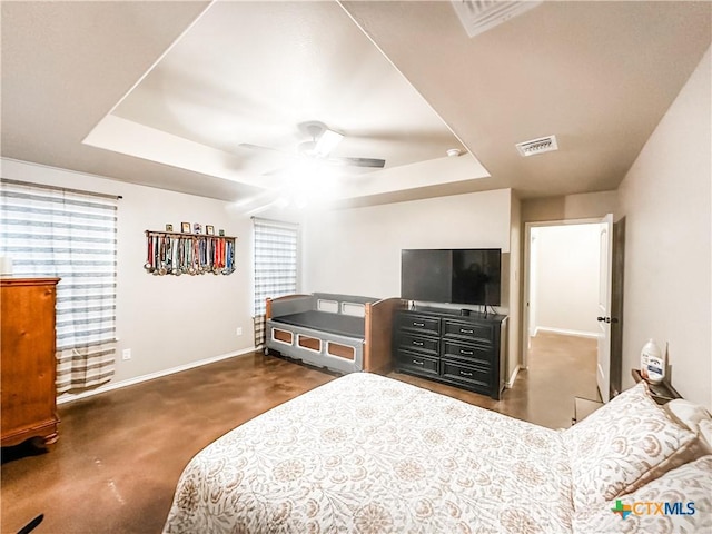 bedroom featuring ceiling fan, a raised ceiling, and dark colored carpet