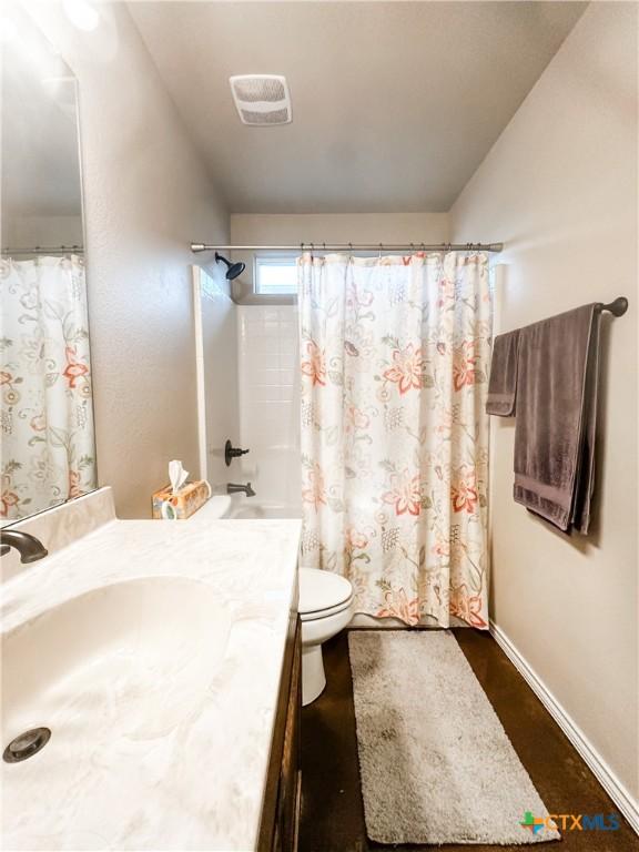 full bathroom featuring vanity, hardwood / wood-style flooring, shower / bath combination with curtain, and toilet