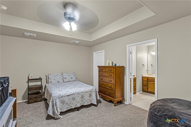1703 Fossil Trl, Belton, TX 76513 - bedroom featuring light carpet, a tray ceiling, ceiling fan, and connected bathroom