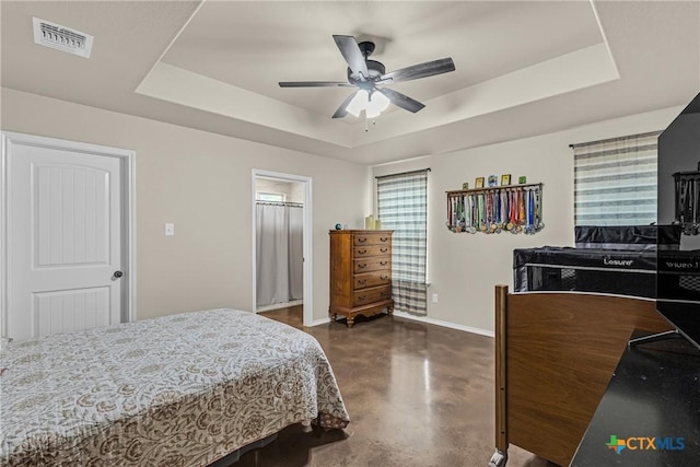 1703 Fossil Trl, Belton, TX 76513 - bedroom with visible vents, baseboards, ceiling fan, a tray ceiling, and finished concrete floors