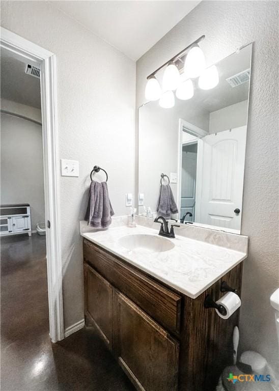 bathroom with vanity, concrete floors, and toilet