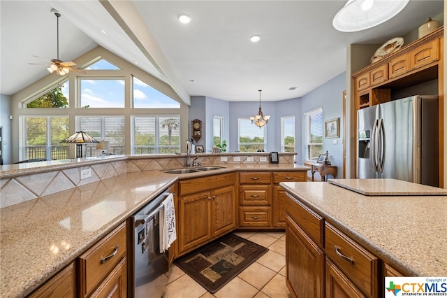 kitchen featuring appliances with stainless steel finishes, lofted ceiling, a healthy amount of sunlight, and sink