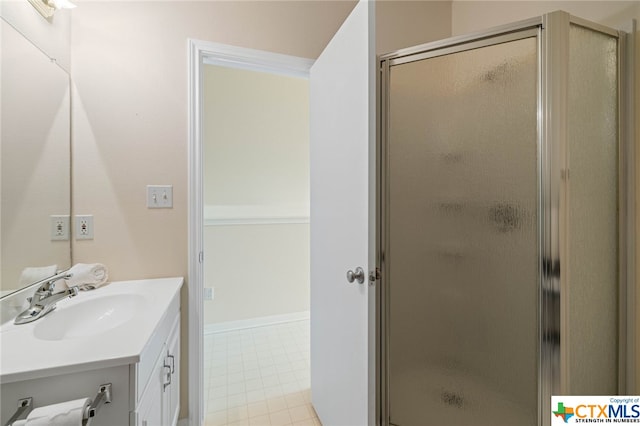 bathroom featuring a shower with shower door and vanity