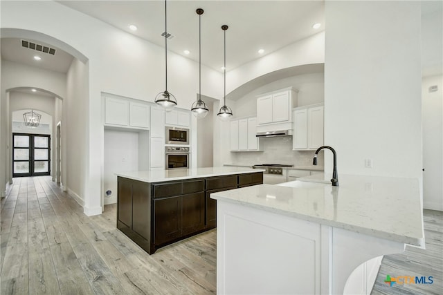 1923 Privet Rd, New Braunfels, TX 78132 - kitchen featuring appliances with stainless steel finishes, under cabinet range hood, white cabinetry, light wood-style floors, and recessed lighting