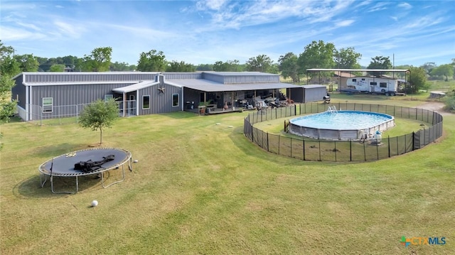 1622 Old Goliad Rd, Victoria, TX 77905 - back of house with a trampoline and board and batten siding