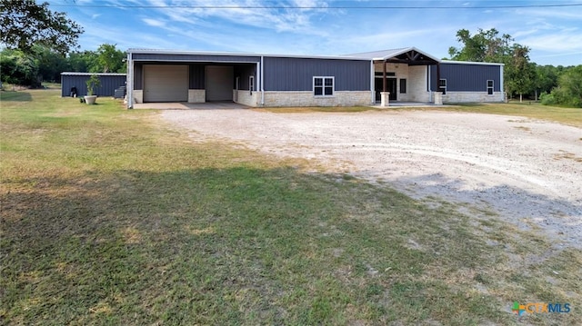 1622 Old Goliad Rd, Victoria, TX 77905 - view of front of house with stone siding, a front yard, an outdoor structure, and a garage
