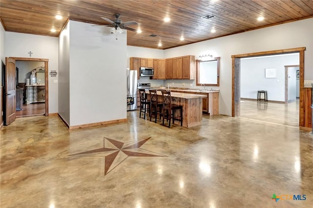 1622 Old Goliad Rd, Victoria, TX 77905 - kitchen with appliances with stainless steel finishes, concrete floors, wood ceiling, a breakfast bar, and ceiling fan