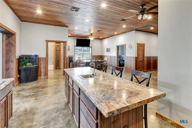 1622 Old Goliad Rd, Victoria, TX 77905 - kitchen featuring a sink, a ceiling fan, wainscoting, wooden ceiling, and concrete floors