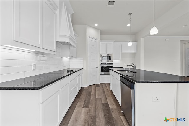 kitchen featuring a kitchen island with sink, white cabinetry, sink, and stainless steel appliances