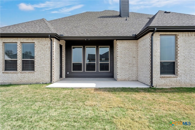 back of property with a yard and a patio area