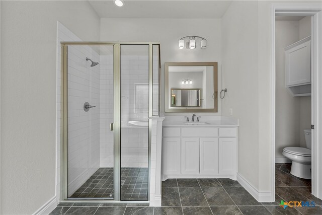 bathroom with toilet, vanity, tile patterned floors, and a shower with shower door