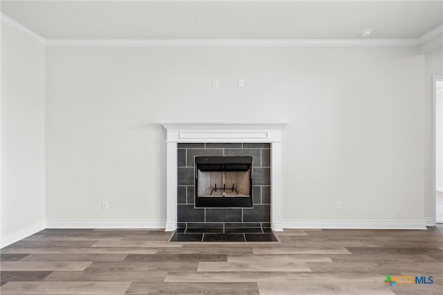 room details featuring a fireplace, hardwood / wood-style flooring, and crown molding
