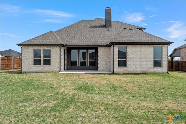 rear view of house with a yard and a patio area