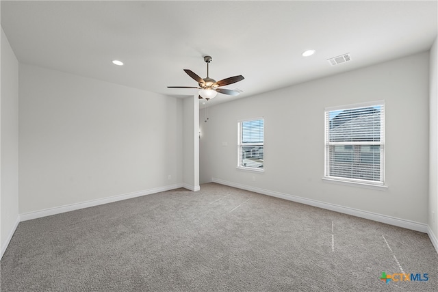 empty room with ceiling fan and light carpet