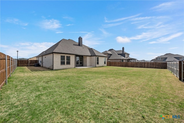 rear view of property with a lawn and a patio