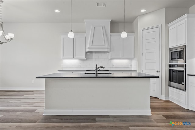 kitchen featuring stainless steel appliances, white cabinetry, and pendant lighting