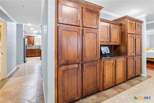 213 Gracie Ct, Harker Heights, TX 76548 - kitchen with freestanding refrigerator, ornamental molding, brown cabinetry, baseboards, and recessed lighting
