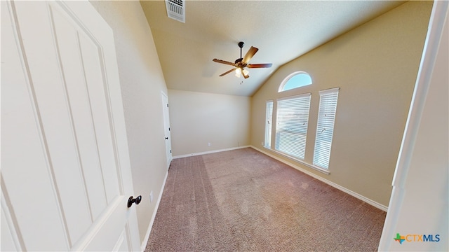 carpeted empty room featuring ceiling fan and vaulted ceiling