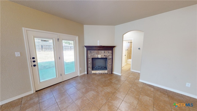 unfurnished living room featuring a fireplace and light tile patterned flooring