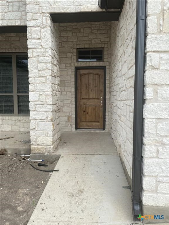 property entrance with stone siding