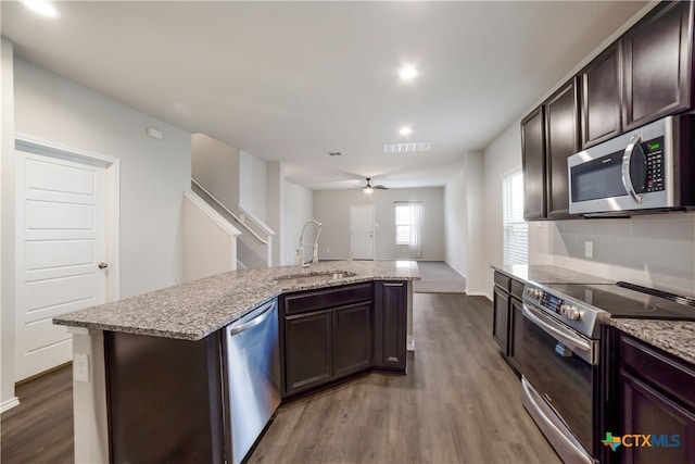 7147 Azure Waters, Converse, TX 78109 - kitchen with appliances with stainless steel finishes, wood finished floors, dark brown cabinetry, open floor plan, and recessed lighting