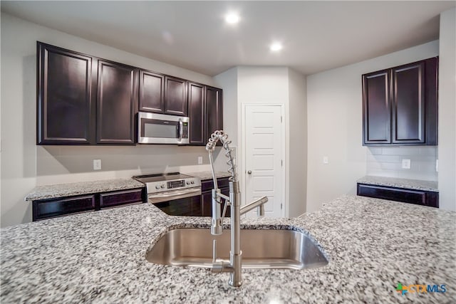 7147 Azure Waters, Converse, TX 78109 - kitchen with stainless steel appliances, dark brown cabinetry, recessed lighting, tasteful backsplash, and light stone counters