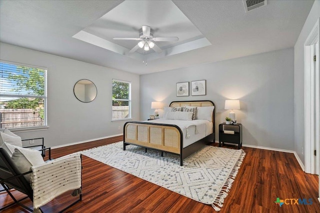 2102 Garrison Dr, Leander, TX 78641 - bedroom featuring wood finished floors, a tray ceiling, and ceiling fan