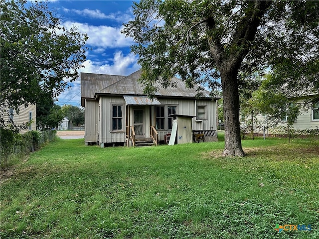 rear view of house featuring a lawn