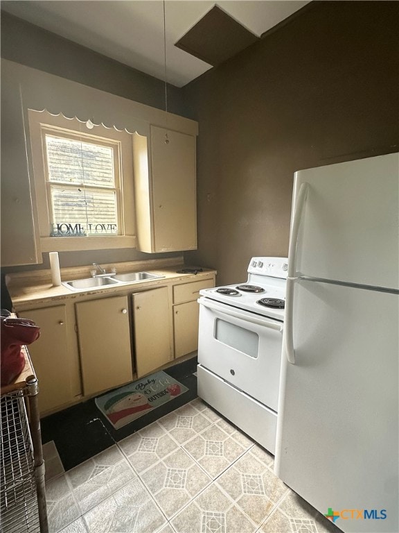 kitchen with cream cabinets, sink, white appliances, and light tile patterned flooring