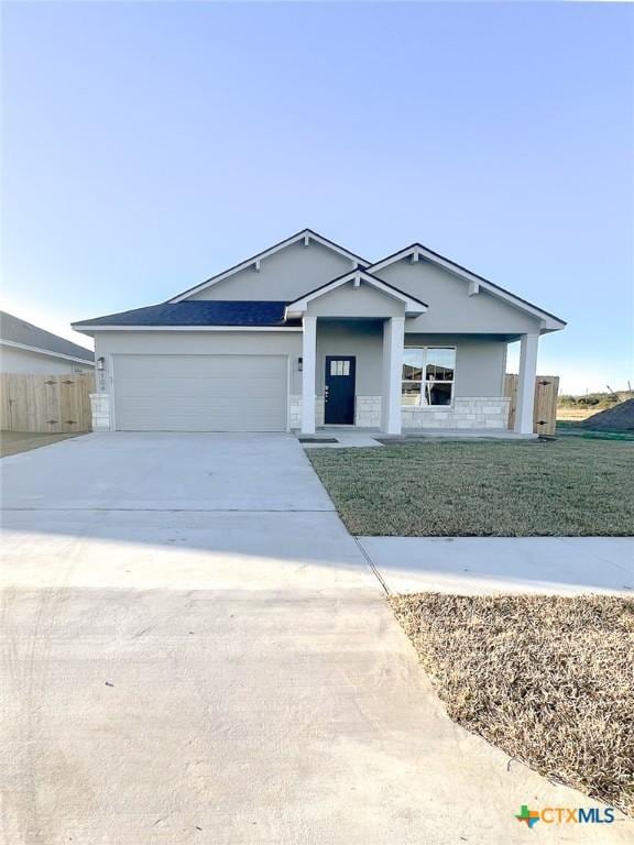 ranch-style house featuring a garage, a porch, and a front yard