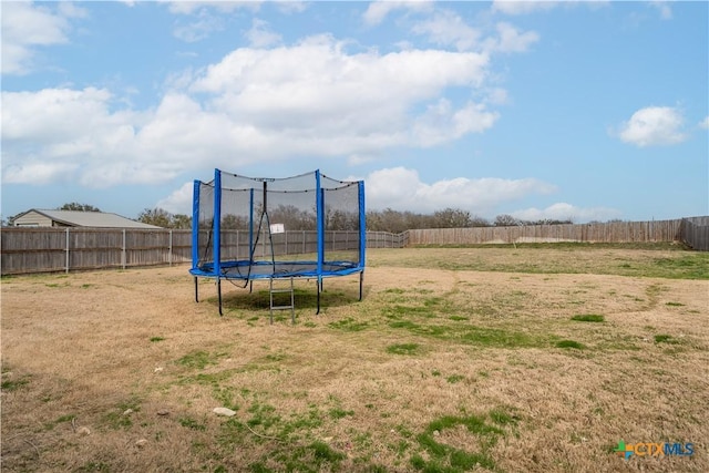 view of jungle gym with a trampoline and a fenced backyard