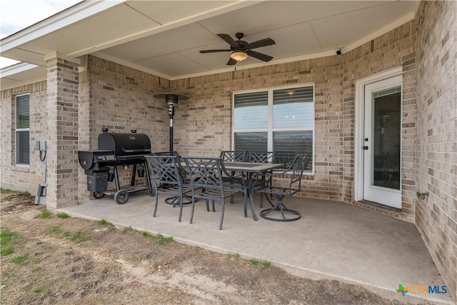 view of patio featuring a ceiling fan, outdoor dining space, and a grill