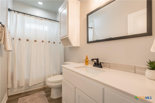 bathroom with shower / bath combination with curtain, vanity, toilet, and wood finished floors