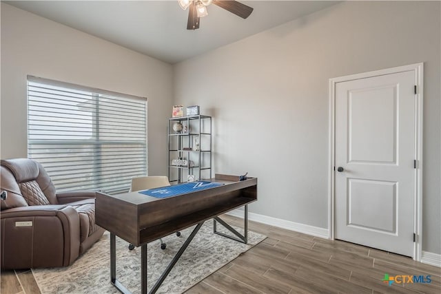 home office with baseboards, a ceiling fan, and wood finish floors