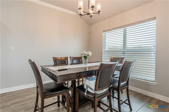 dining room with an inviting chandelier, baseboards, and light wood finished floors