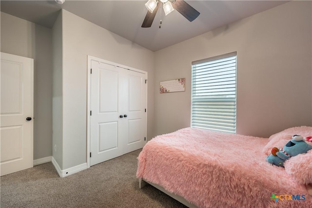 carpeted bedroom with ceiling fan, a closet, and baseboards