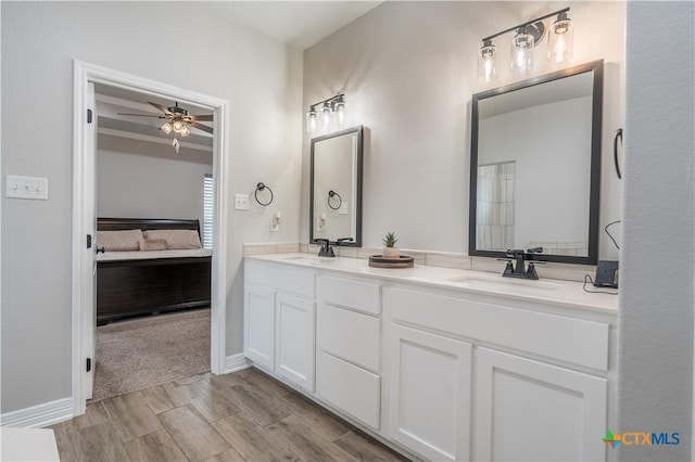 full bath featuring double vanity, ceiling fan, a sink, and ensuite bathroom