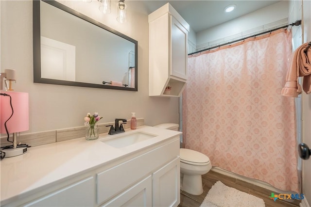 full bathroom featuring wood finish floors, vanity, and toilet