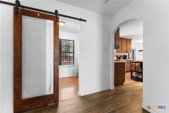 2106 Antelope Trl, Harker Heights, TX 76548 - hall with wood finished floors, a barn door, and arched walkways